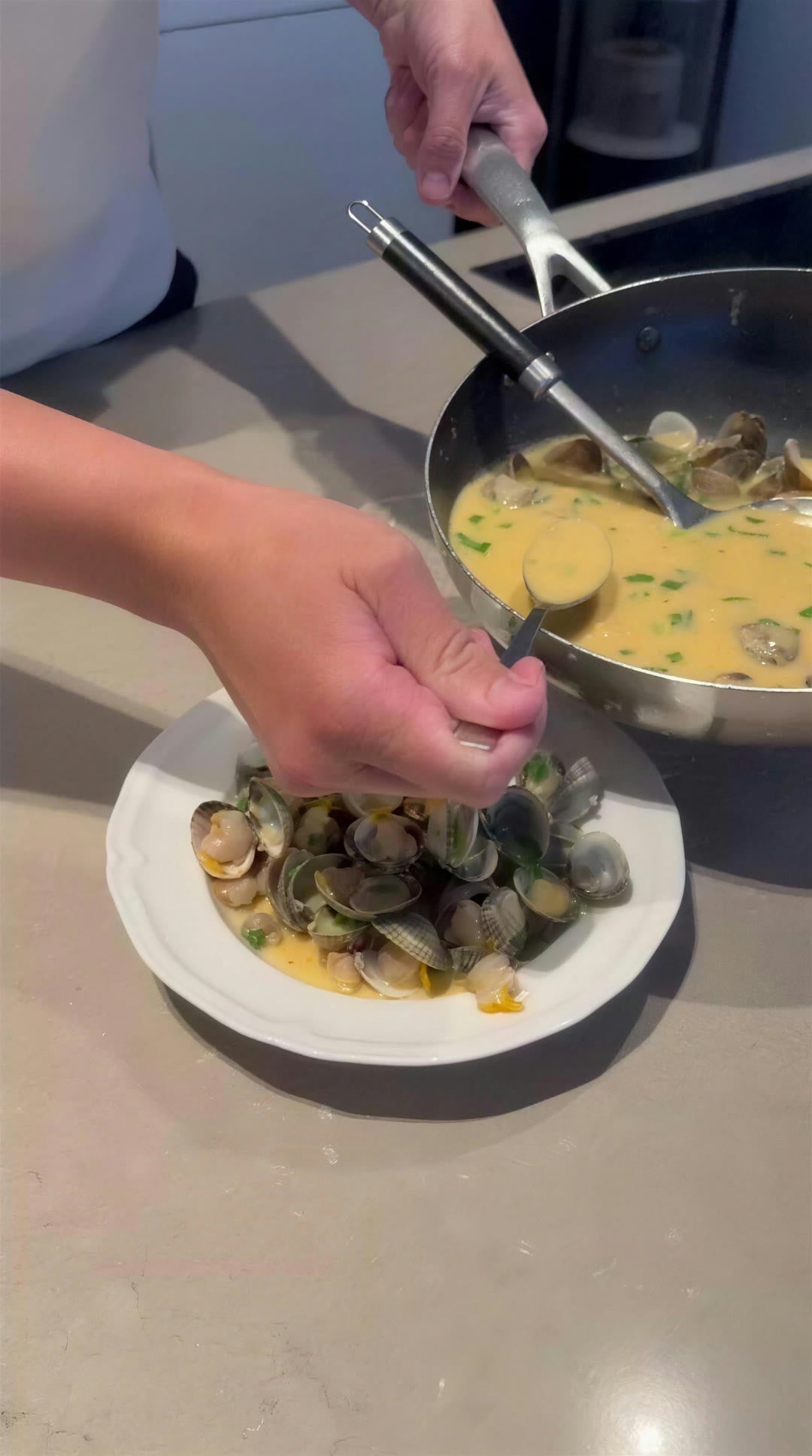 De romige tom yum wordt over de kokkels geschept