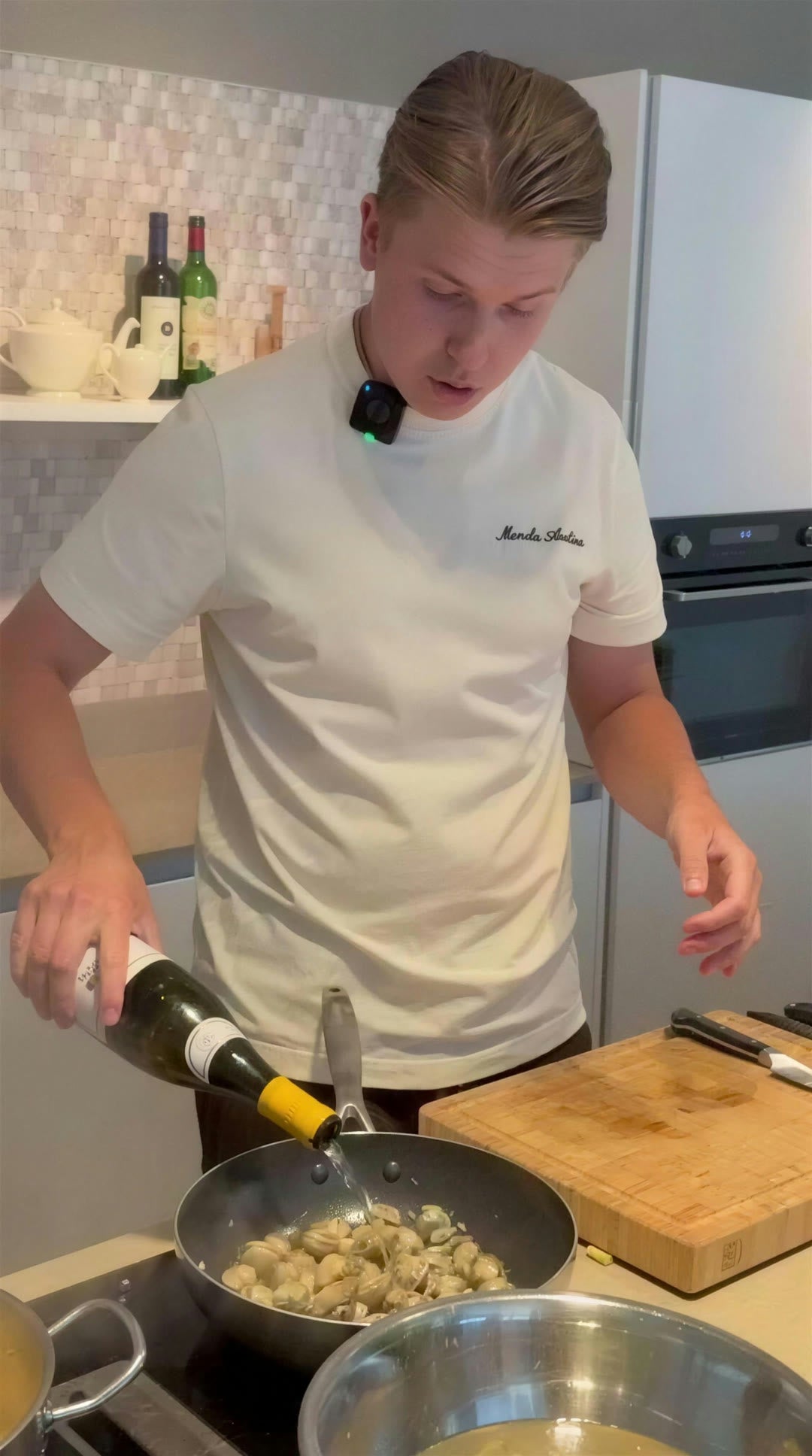 Maarten schenkt witte wijn bij de kokkels